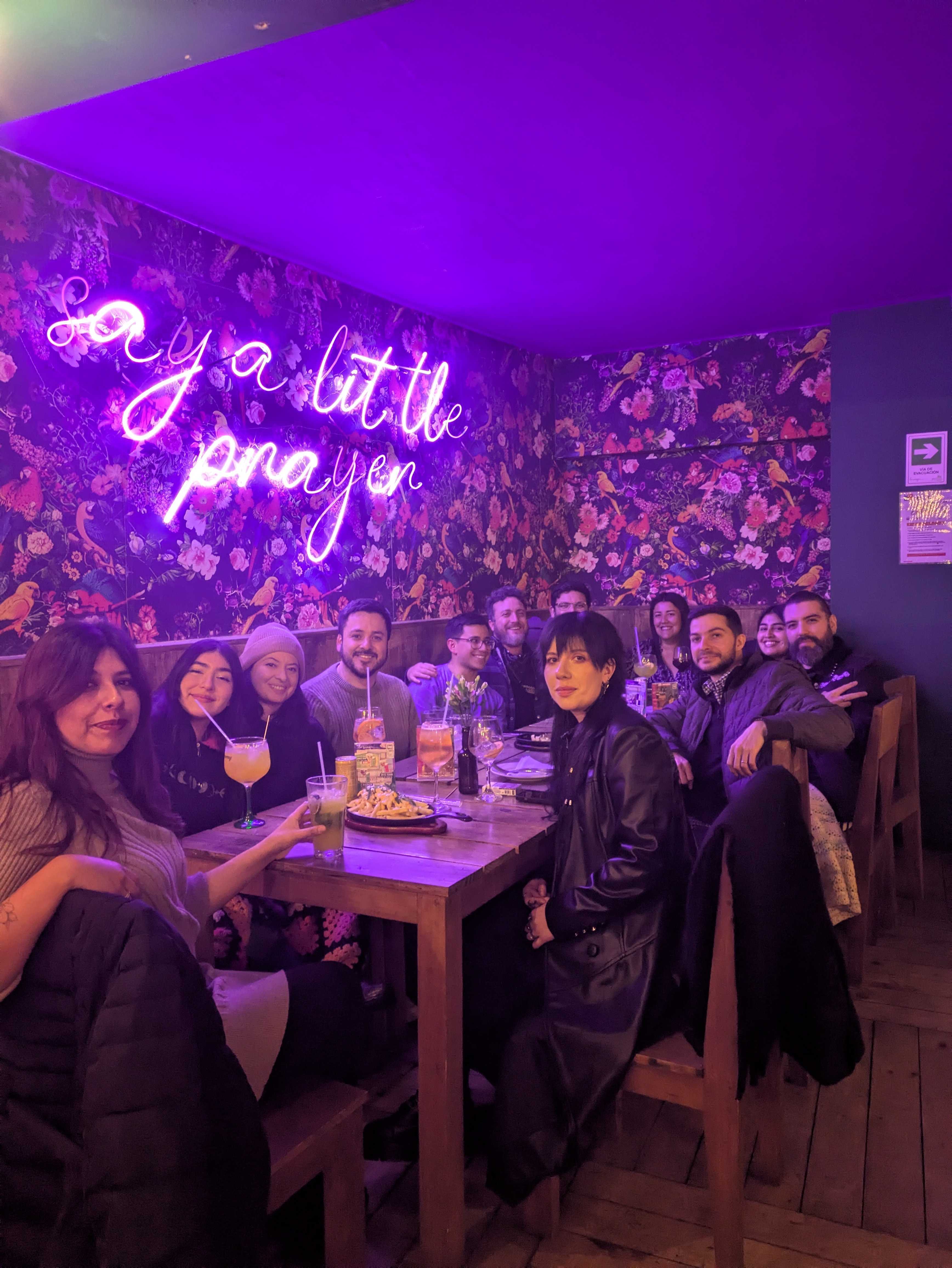 Cena de equipo bajo el letrero Say a little prayer
